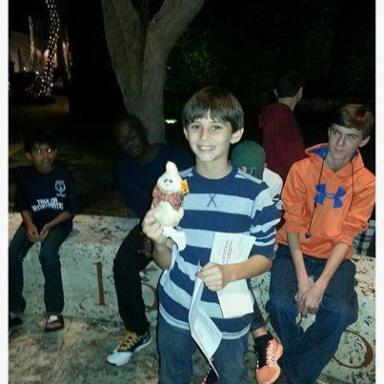 Group of kids seated outside with one holding a small white plushie, surrounded by text about a birthday message.